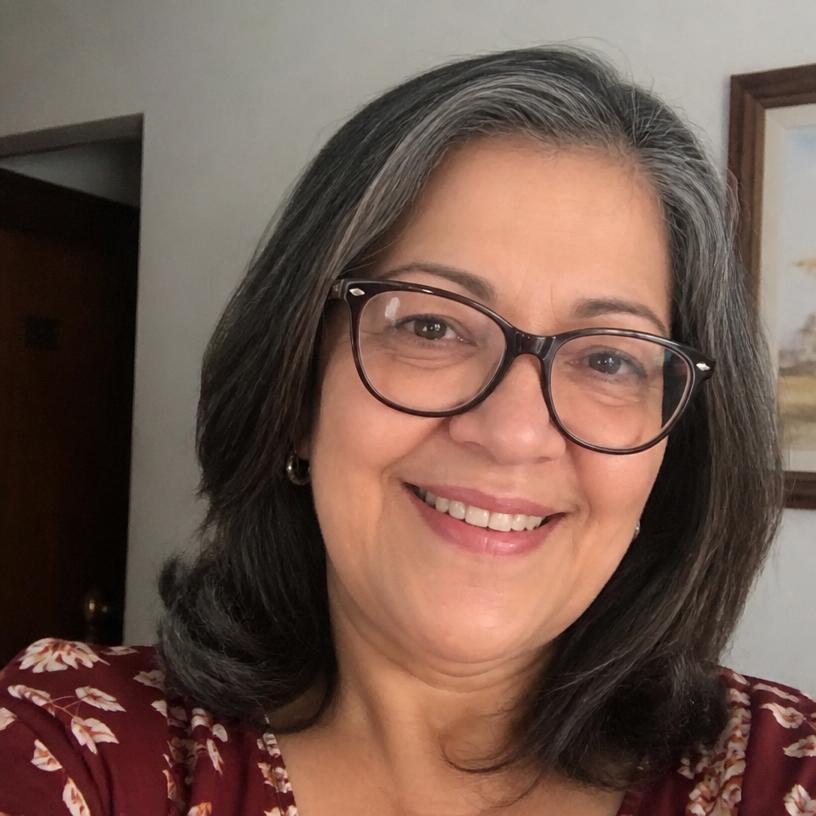 Fernanda, cliente do grupo, de óculos sorrindo em casa